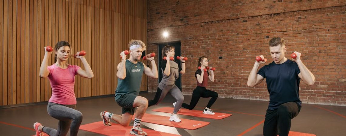 Indoor group workout session with dumbbells focusing on strength and fitness.
